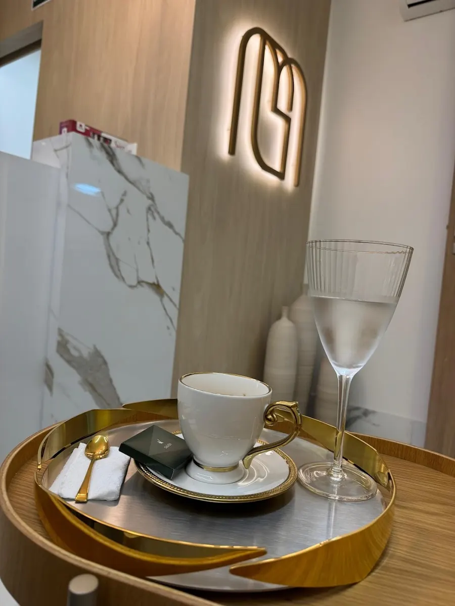 Café e água servidos na recepção, com o monograma GM iluminado